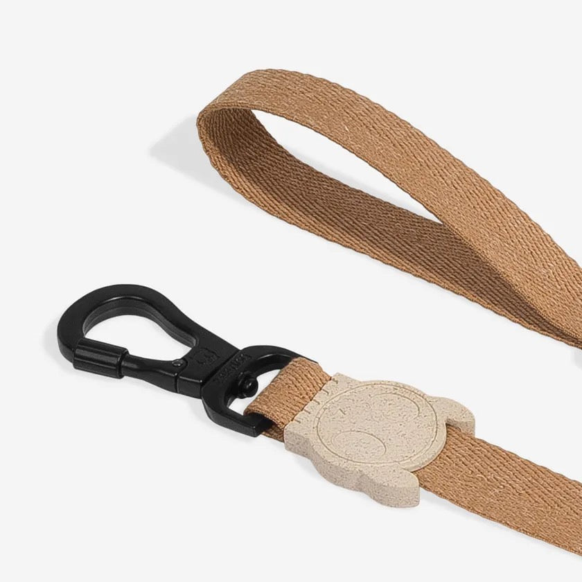 Close front view of the Leash Dune emphasizing its detailed stitching and clasp design.

