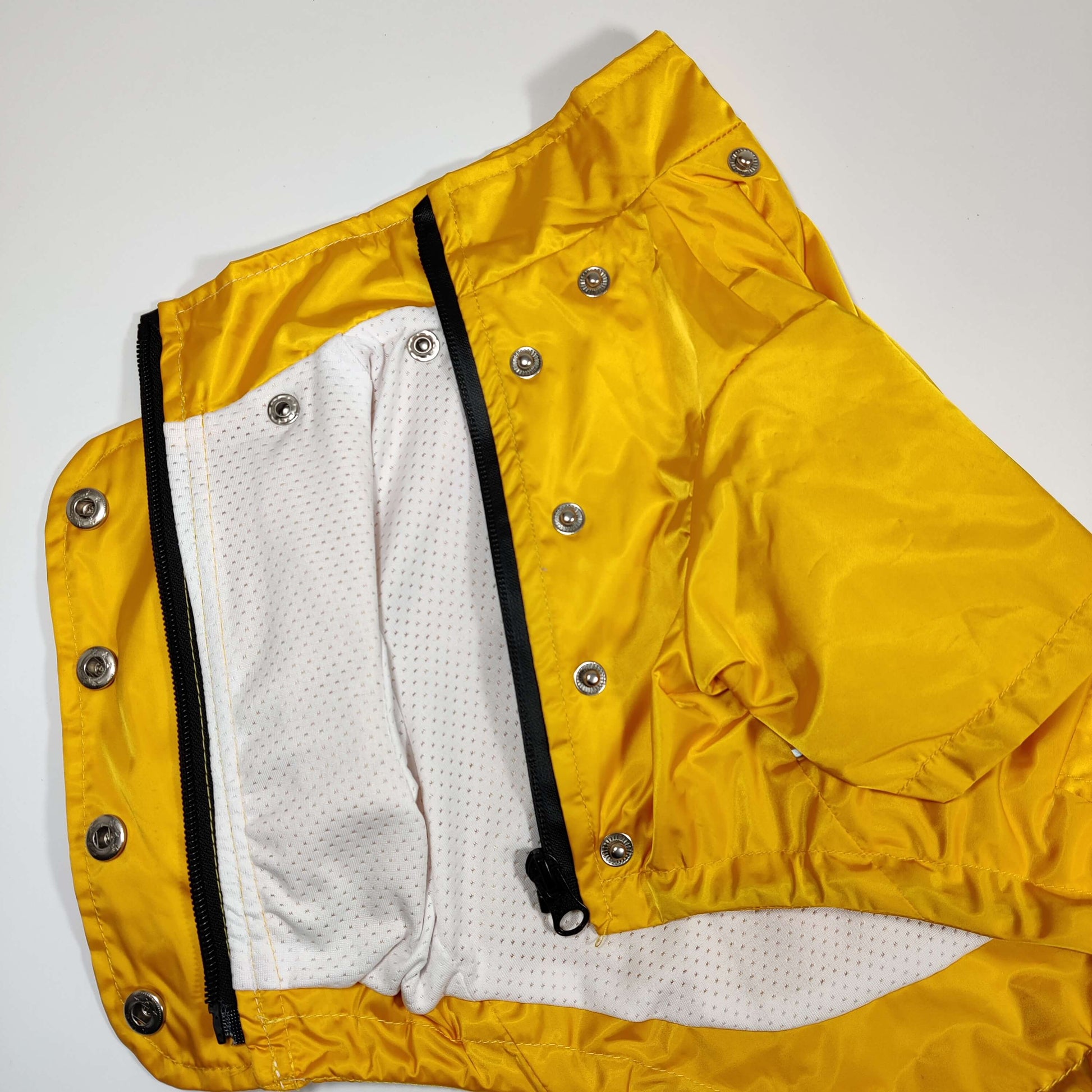 Bottom view of the Yellow 'Buddy' Dog Raincoat showcasing fasteners and interior lining.